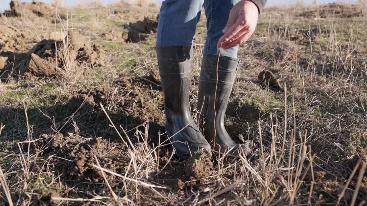 pies con botas compactando el suelo - de cerca