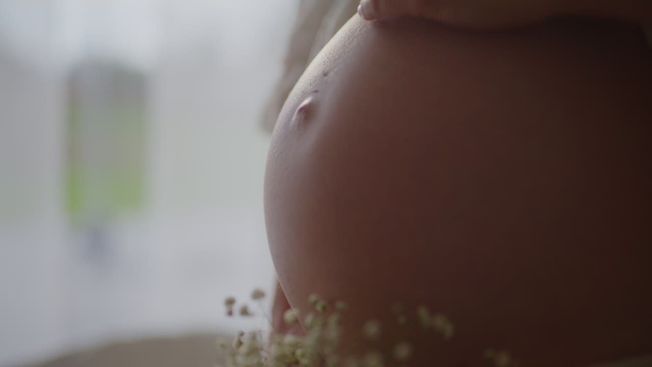 Donna incinta che accarezza la pancia all'ottavo mese