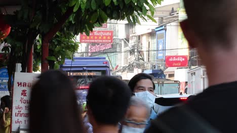 crowded city street with pedestrians wearing masks