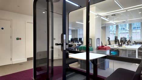 modern soundproof acoustic pod booth with closing door in a coworking open space office with natural light