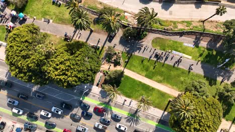 up top view of santa monicas beach entrance with cars palms and people walking