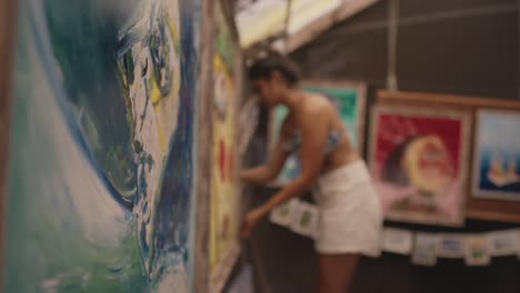 beautiful artwork is hanging on the walls, and a girl is working in the background