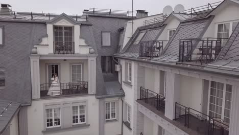 bride standing on a balcony in a white wedding dress