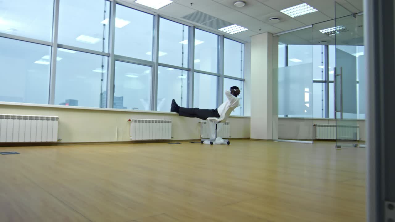 hombre de negocios relajado mirando por la ventana en la nueva oficina vacía
