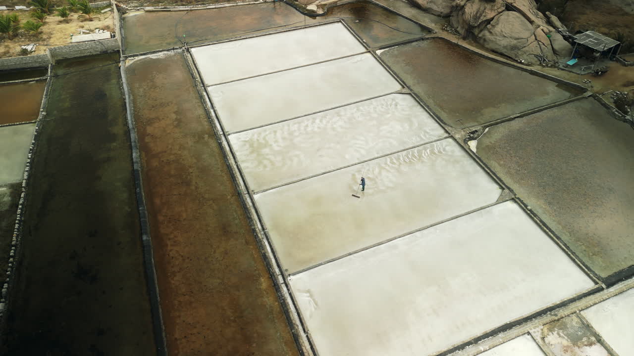 Aerial View of Worker Harvesting Salt in Salt Fields