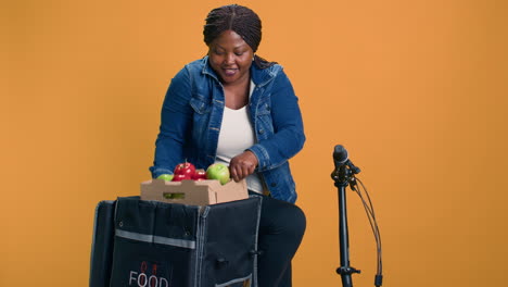 courier grasps box of fresh produce