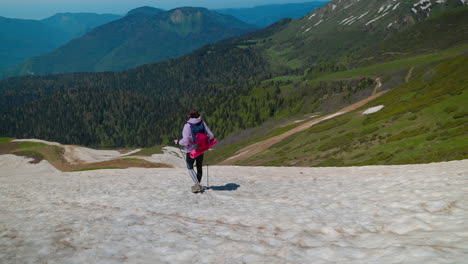 mujer caminando en montañas nevadas
