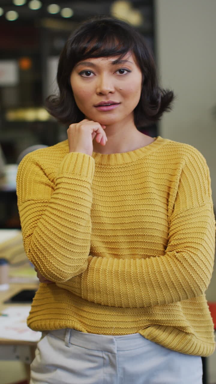 Vertical video of portrait of happy biracial businesswoman at office