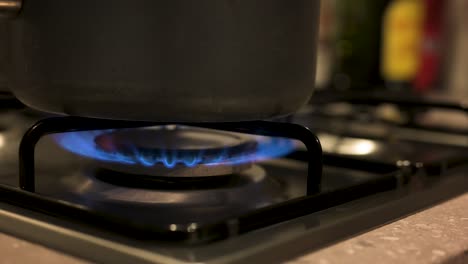 Encender-La-Estufa-De-Gas-Con-Una-Olla-En-La-Parte-Superior-De-Cerca,-Cámara-Lenta