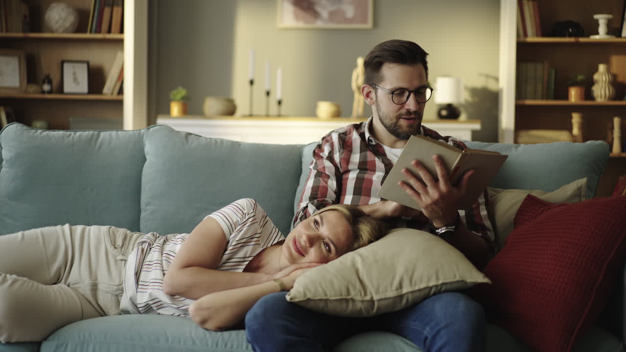 Couple relaxing and reading a book on the couch