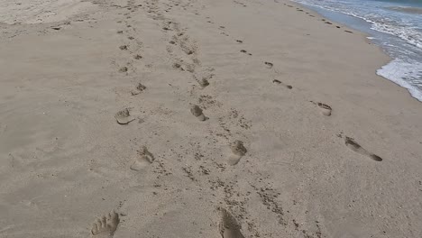 trails of footprints in soft sand on the beach