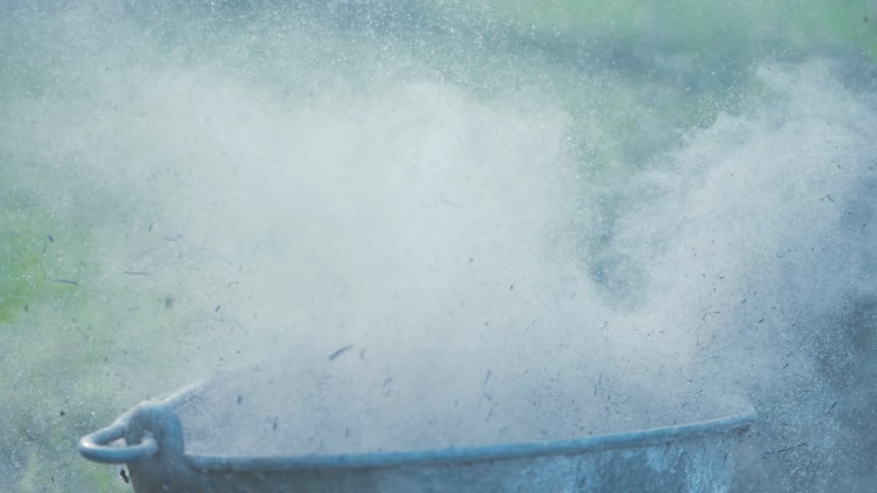 Pouring ashes from shovel into metal bucket