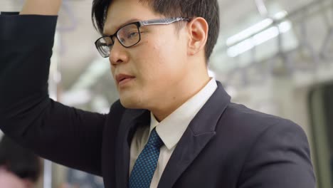 businessman using mobile phone on public train