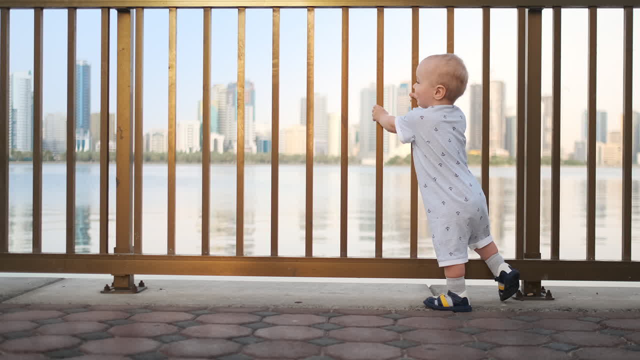 смеющийся мальчик в возрасте 1 года танцует.