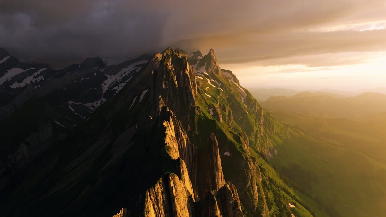 O majestoso pico de Schafler Ridge brilha durante o pôr do sol e o tempo chuvoso em Appenzell, Suíça.