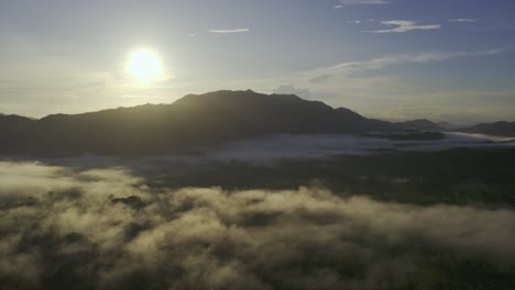 Bright-Sun-In-Blue-Sky-Over-Dark-Shadow-Mountain-Of-Costa-Rican-Jungle-With-Cloud,-4K-Drone