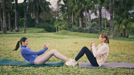 athletic team fitness workout park. athletes enjoying partners crunches training