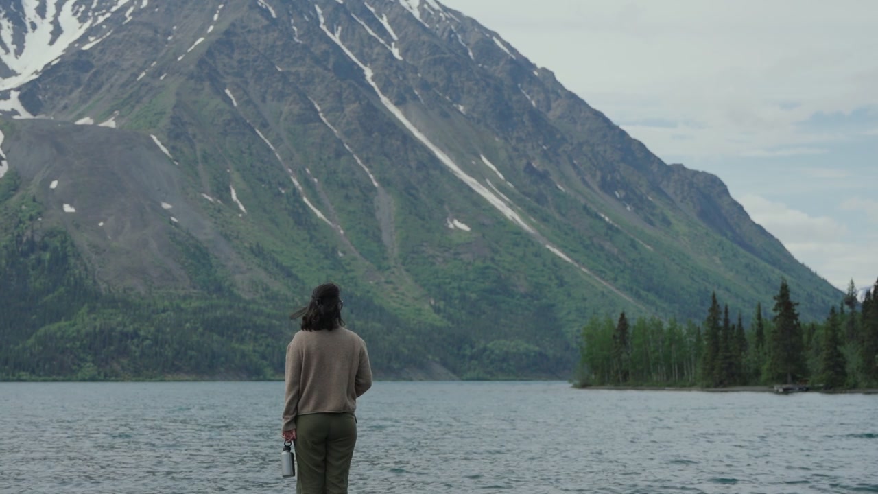 Woman admiring mountains from Kathleen Lake in Yukon, Canada
