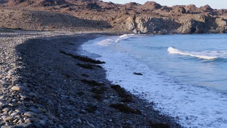 small ocean waves break onto steep pebble beach in chile atacama coast