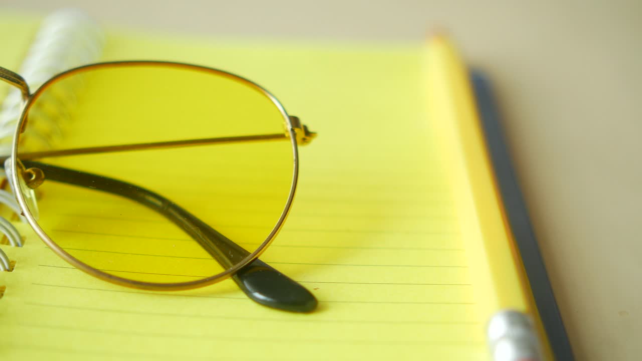 gafas de sol redondas amarillas en un cuaderno