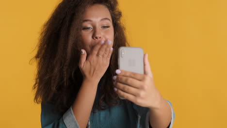 una mujer caucásica de cabello rizado llamando por teléfono.