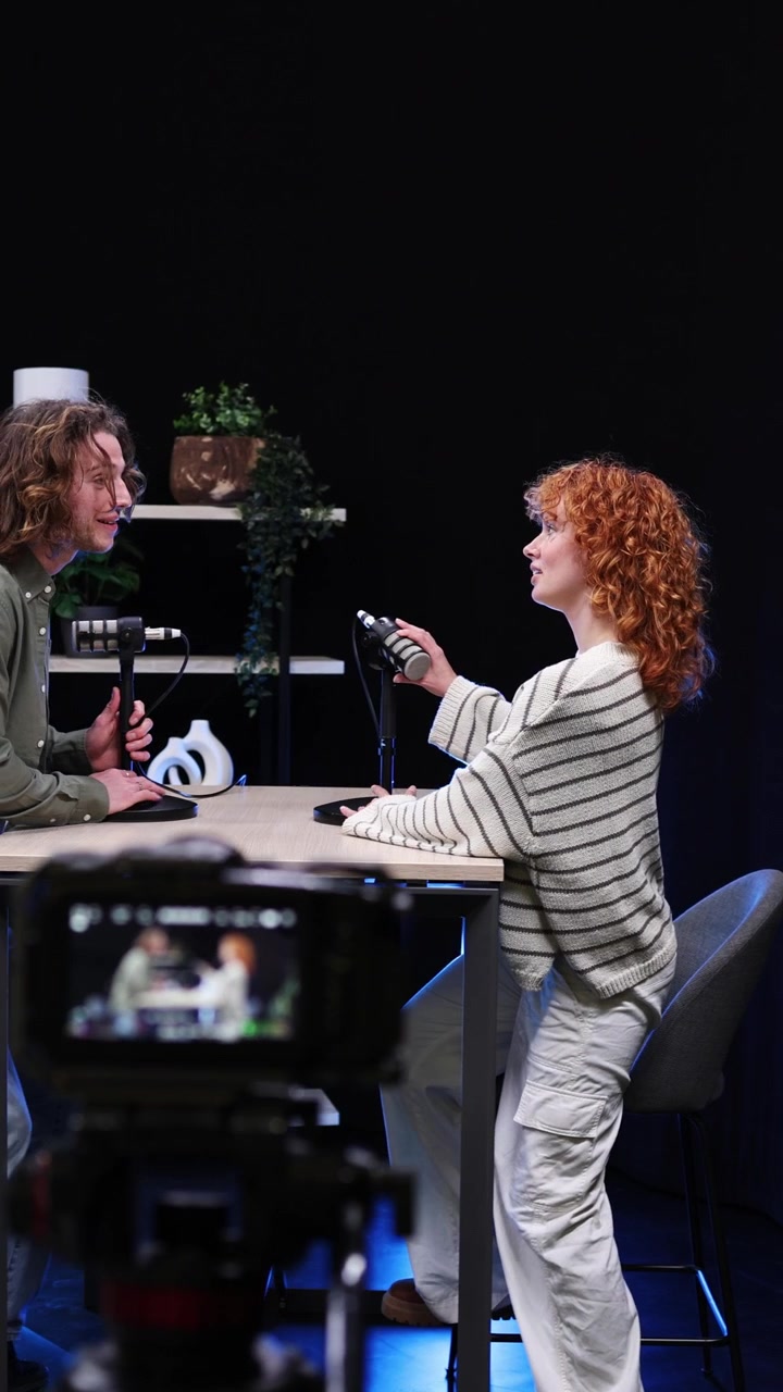 Mand og kvinde gør klar til podcastinterview i studie