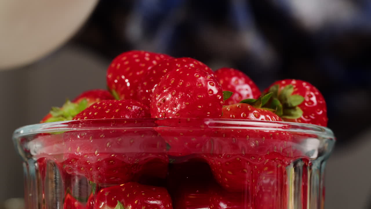 Cream Being Poured Over Fresh Red Strawberries in a Glass Bowl
