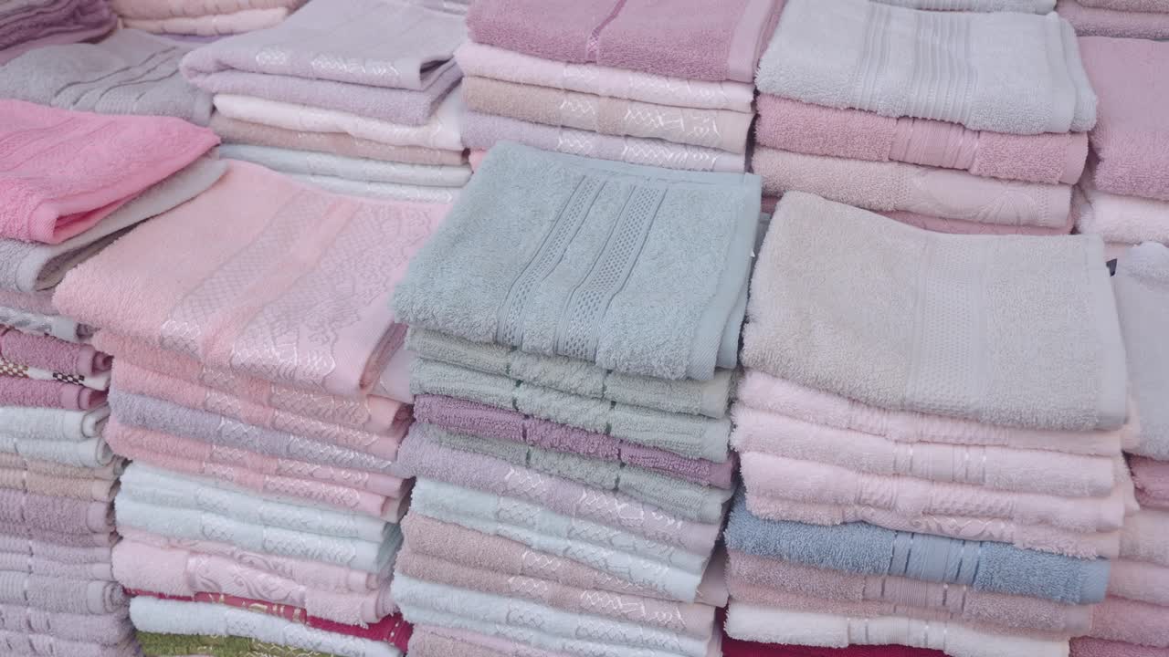 pilas de toallas plegadas en colores pastel para la venta