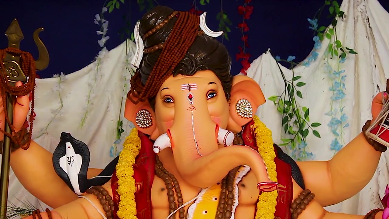 Ganesha idol dressed as Shiva face closeup with trishul and rudraksha, blue eyes tripundra tilak, Ganesh Chaturthi festival India.