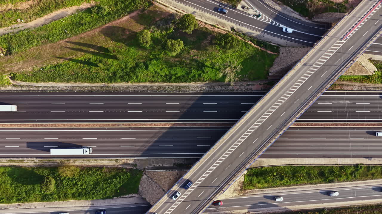 Svincolo autostradale in una zona rurale con numerosi veicoli in transito durante le ore diurne.