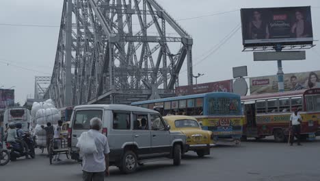 howrah bridge and bustling street traffic in kolkata, india