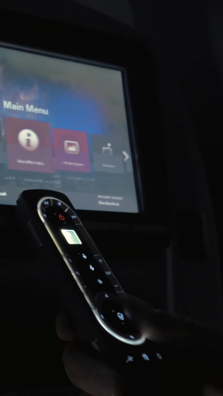Persona che utilizza il sistema di intrattenimento in volo con telecomando