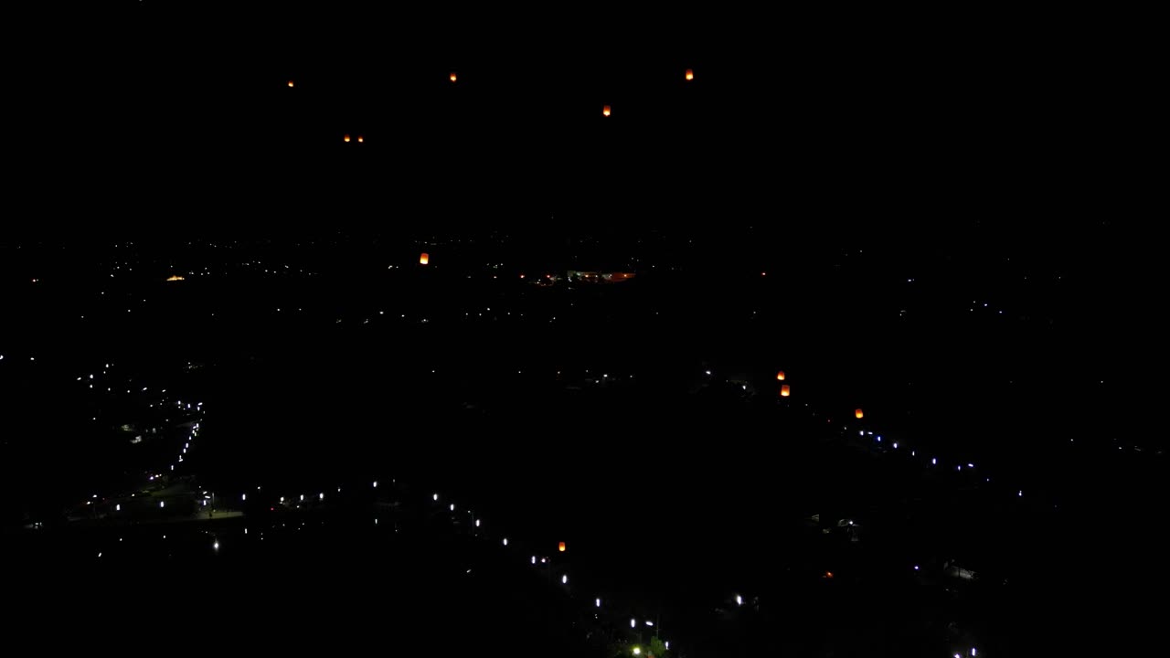 태국에 떠 있는 등불로 어두운 밤하늘을 가로지르는 공중 비행