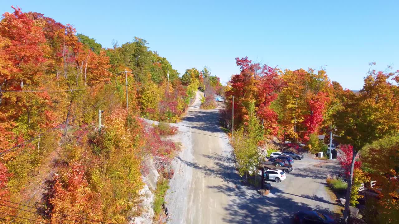 Autumn aerial view of a rural road in Estrie, Québec, surrounded by colorful trees