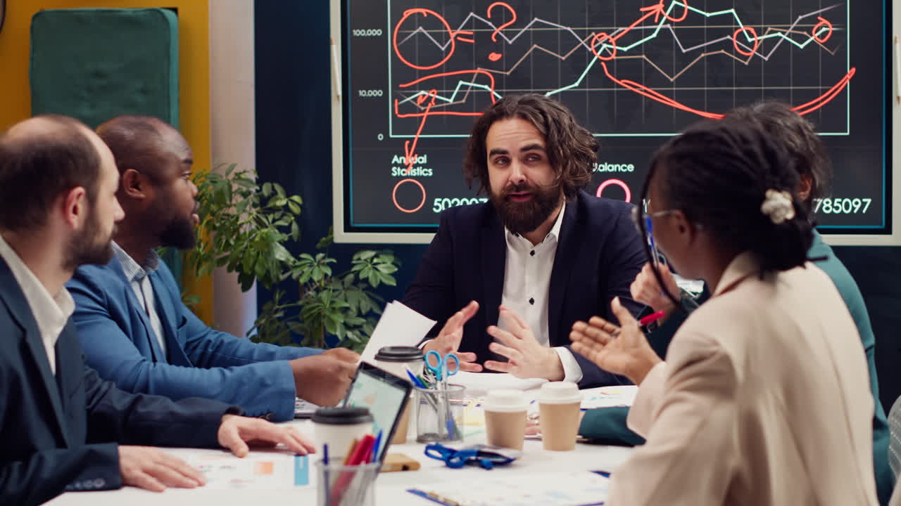 스타트업 팀이 임원 회의에서 인포그래픽 데이터를 평가하고 있습니다.