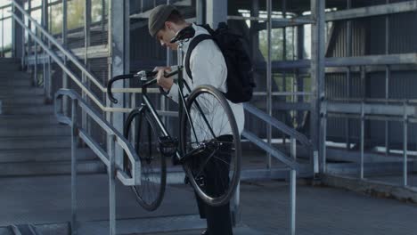 man carrying bicycle up stairs