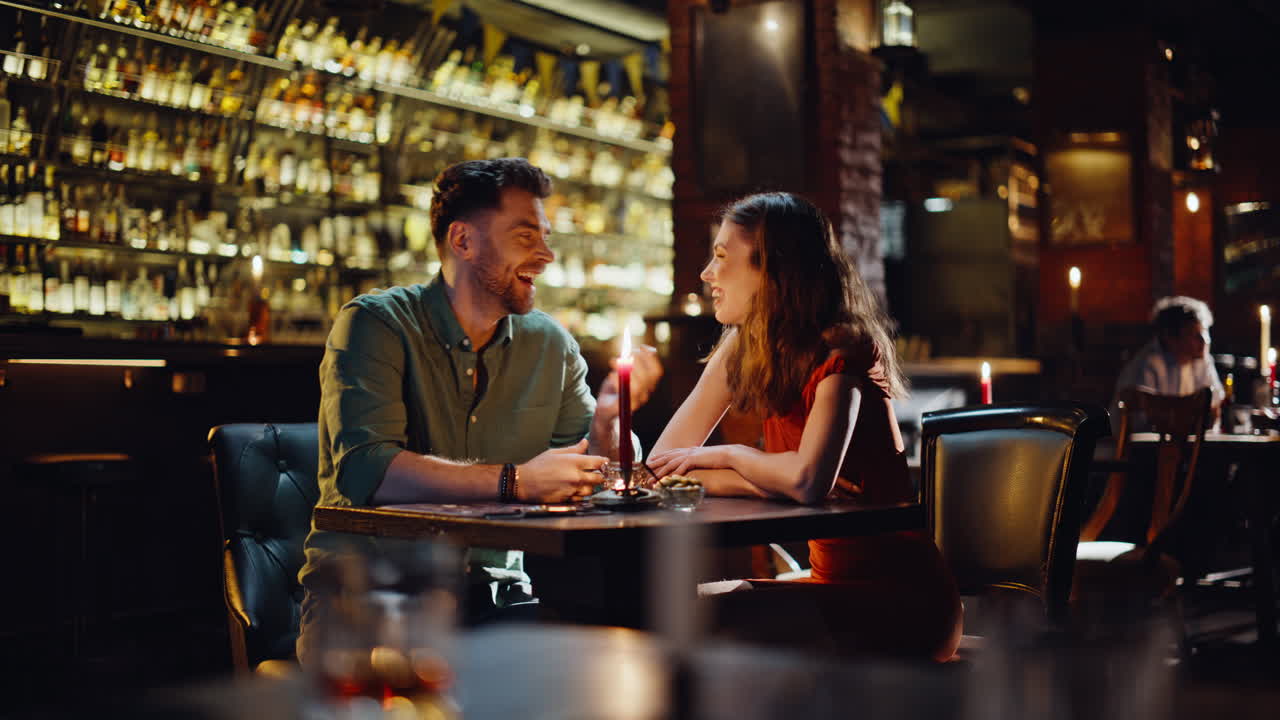 Una coppia innamorata che parla in un bar e si gode un'atmosfera romantica e accogliente. Coppia romantica sorridente
