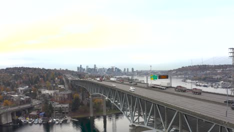 Toma-Aérea-Ascendente-De-Automóviles-Que-Conducen-Sobre-El-Puente-Del-Canal-De-Barcos-En-Seattle