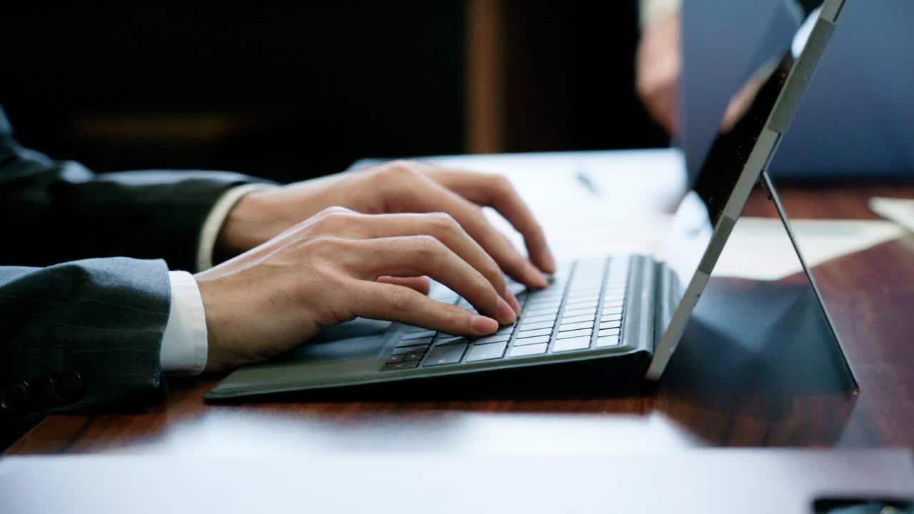 Asian business person typing on a computer
