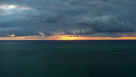 Gorgeous-aerial-drone-time-lapse-of-a-vivid-orange-sunrise-with-small-waves-and-tropical-blue-ocean-water-and-below-from-Well-beach-near-Joao-Pessoa,-Brazil