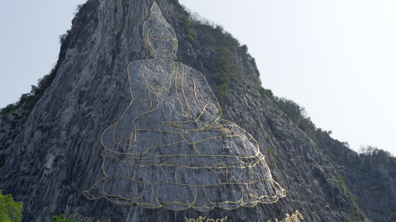uddha Mountain in Pattaya at dawn, golden light on the image of Buddha in Khao Chi Chan, Chonburi, Thailand. Engraved with gold into the hill. Beautiful thai attractions.