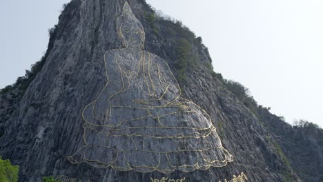 uddha mountain in pattaya at dawn, golden light on the image of buddha in khao chi chan, chonburi, thailand. engraved with gold into the hill. beautiful thai attractions.