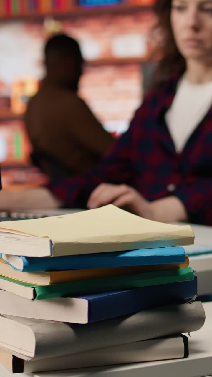 Vertical video Close up of books on startup office desk used by entrepreneur to grow business