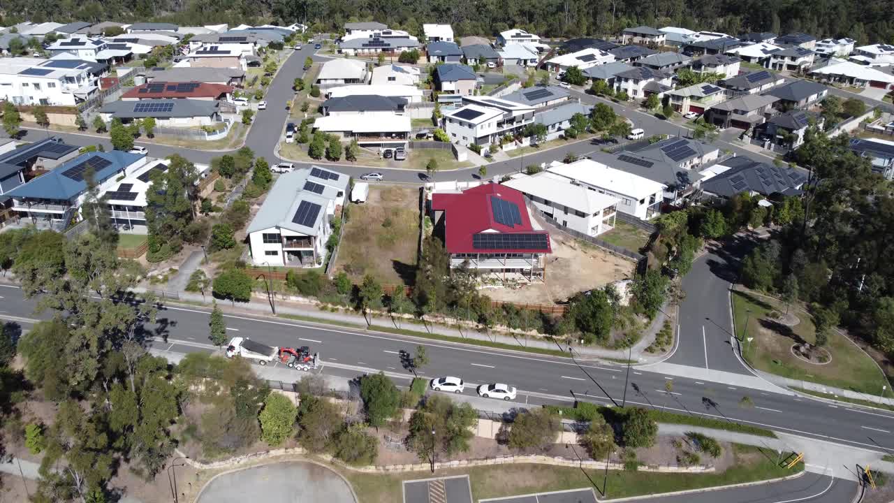 dron volando hacia grandes casas familiares en un suburbio australiano