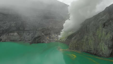 Türkisfarbener-See-Des-Ijen-Vulkankraters-Mit-Weißem-Schwefelrauch-Aus-Der-Mine