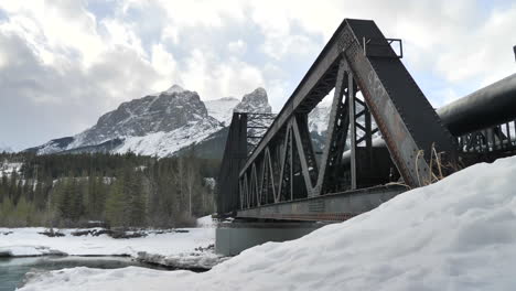 cinematic shot of old bridge over clear water in alberta.
