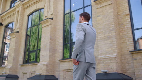 Suit-man-calling-mobile-phone-on-street.-Business-people-using-devices-outside.