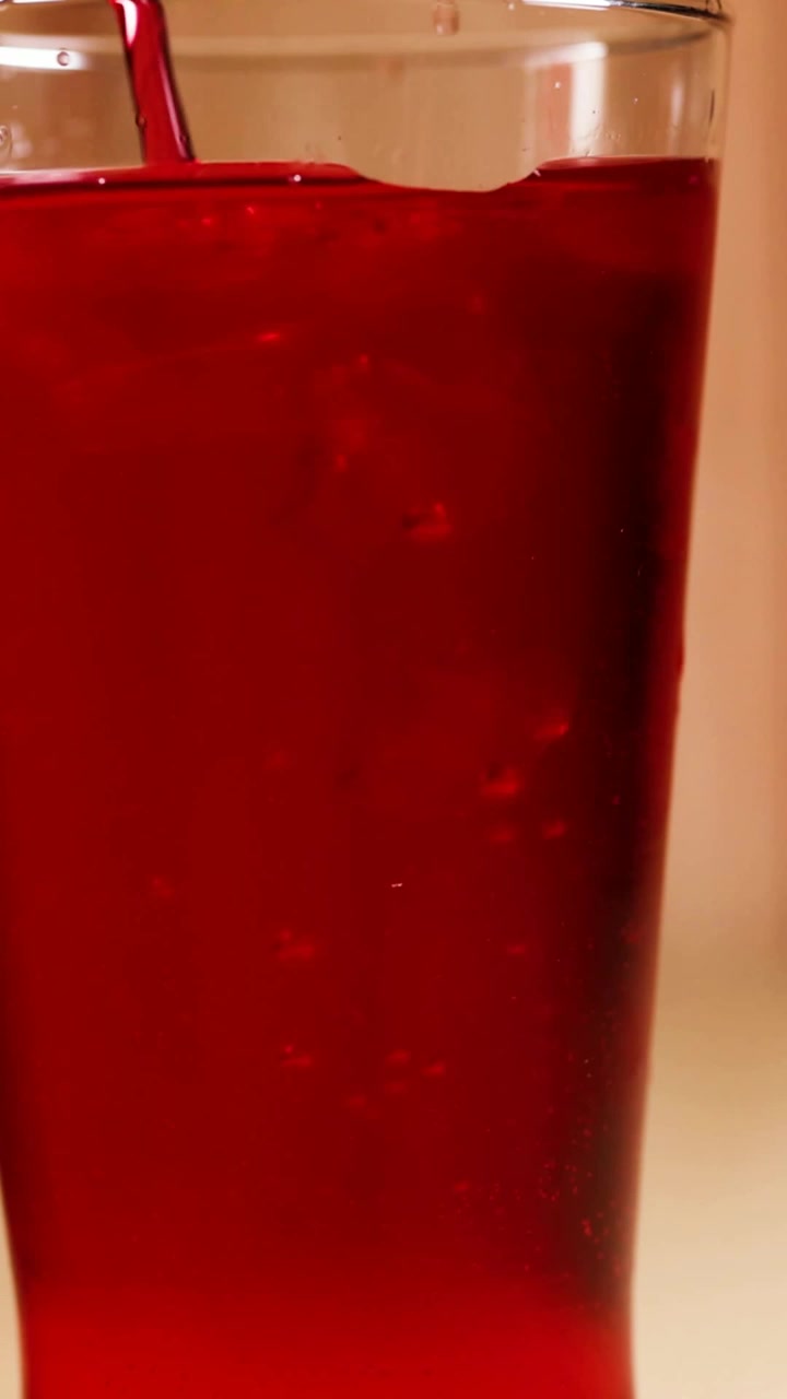 Bevanda rossa versata in un bicchiere
