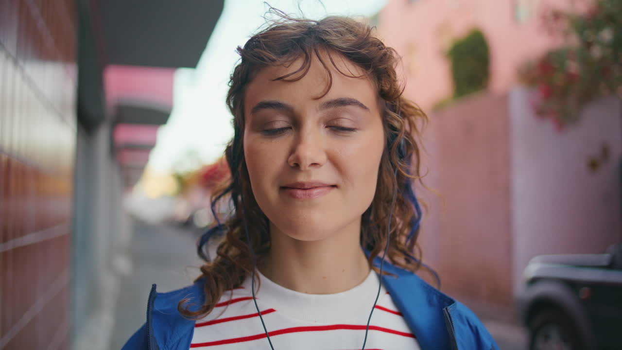 retrato auriculares chica mirando cámara en el barrio urbano en el fin de semana.