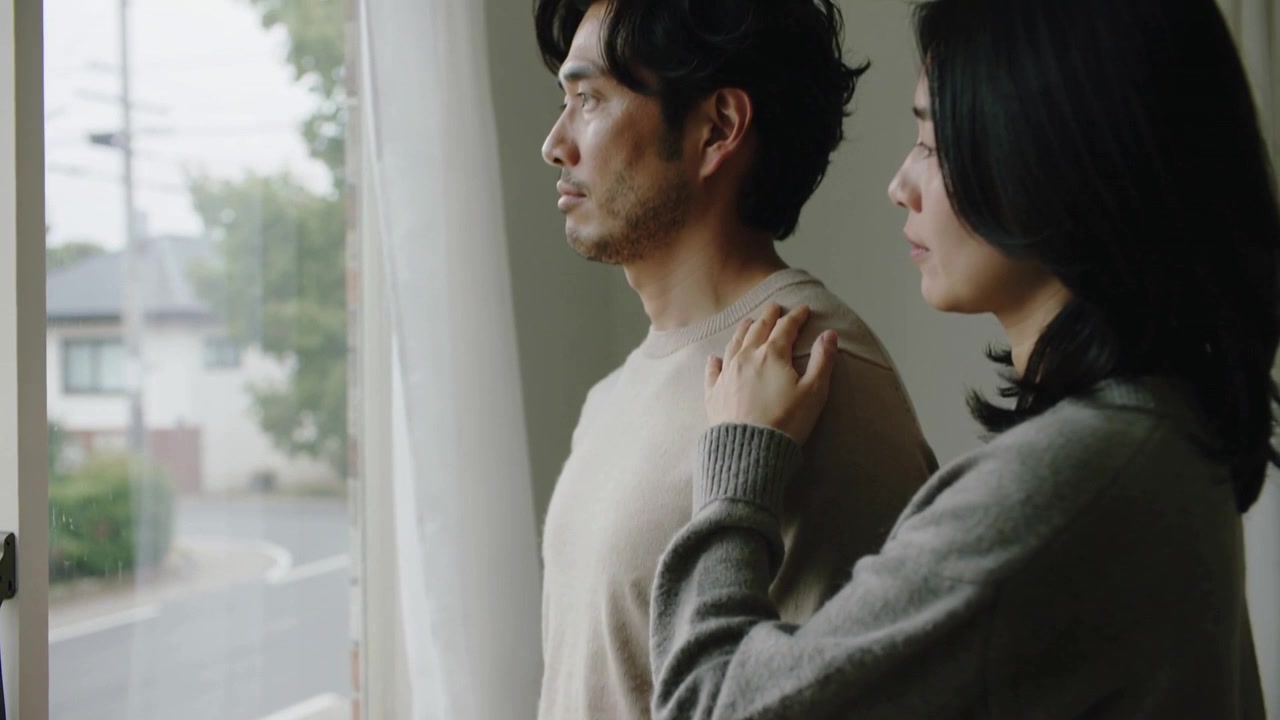 近づいてくる女性が彼の肩に手を置く、キッチンを見つめ慰め合うカップル、バンド、セーター